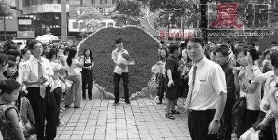 男主角劉航手捧玫瑰和鉆戒,站在9999朵玫瑰擺成的心形花海前,他的舉動也引來了眾多市民的圍觀。圖/讀者私享