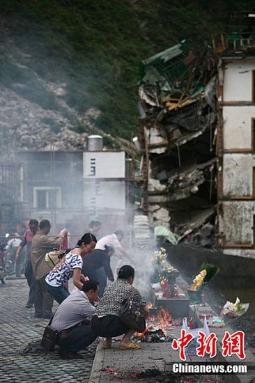 5月10日,離“5.12”汶川特大地震三周年紀念日還有2天,四川北川地區民眾紛紛趕回老縣城遺址敬獻鮮花、燒紙錢祭拜遇難親人。中新社發 張浪 攝