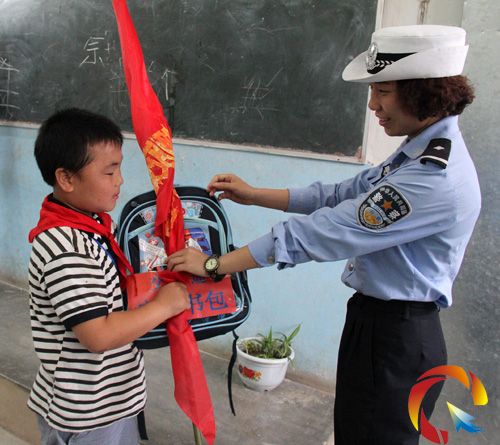 交警為同學(xué)們發(fā)放“交通安全書包”和“文明交通小衛(wèi)士"紅旗"